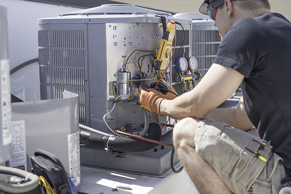 Air conditioner repair in Sea Girt shows technician working on an open condenser