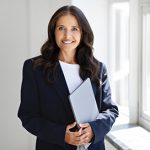 Ortley Beach real estate agent in a black suit holding a folder