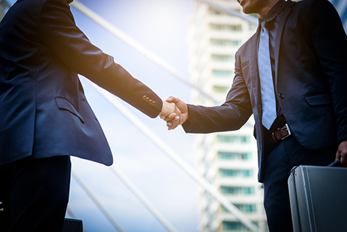 Branch manager shaking hands with ATM service in NJ professional in sunny city setting